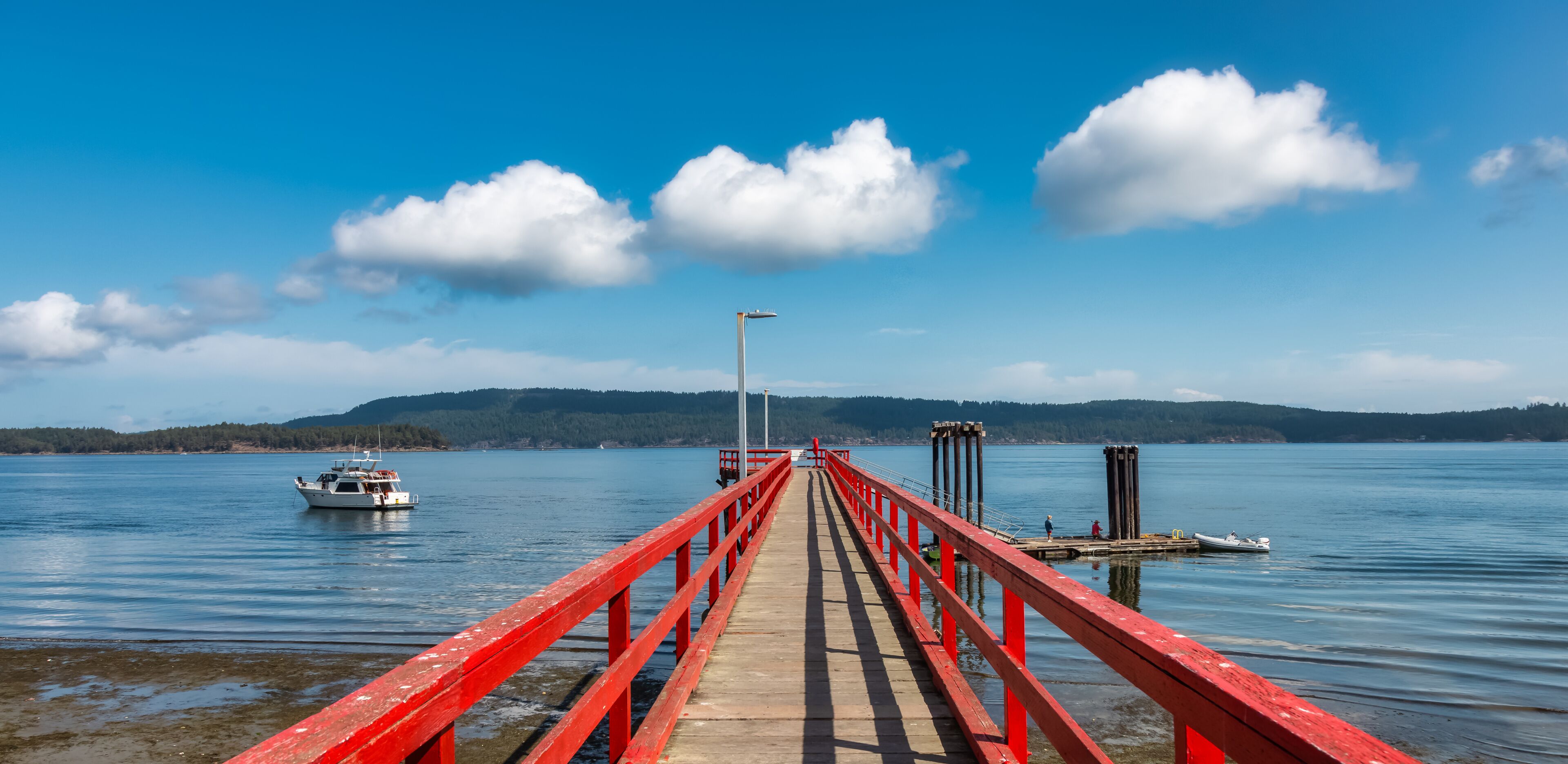 Wooden Pier by the Pacific Ocean West Coast. Sunny Summer Day. Fernwood Point Beach, Salt Spring Island, British Columbia, Canada.