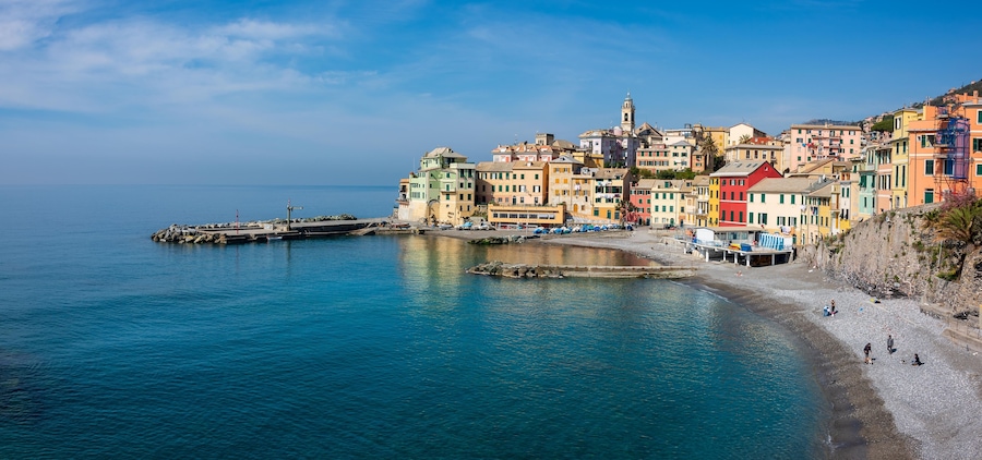 Un pueblo costero con edificios coloridos, un muelle y una playa.