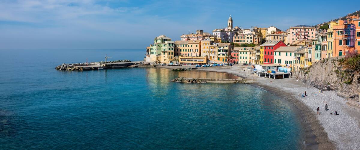 A coastal town with colorful buildings, a pier, and a beach.