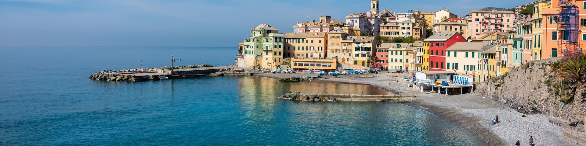 A coastal town with colorful buildings, a pier, and a beach.