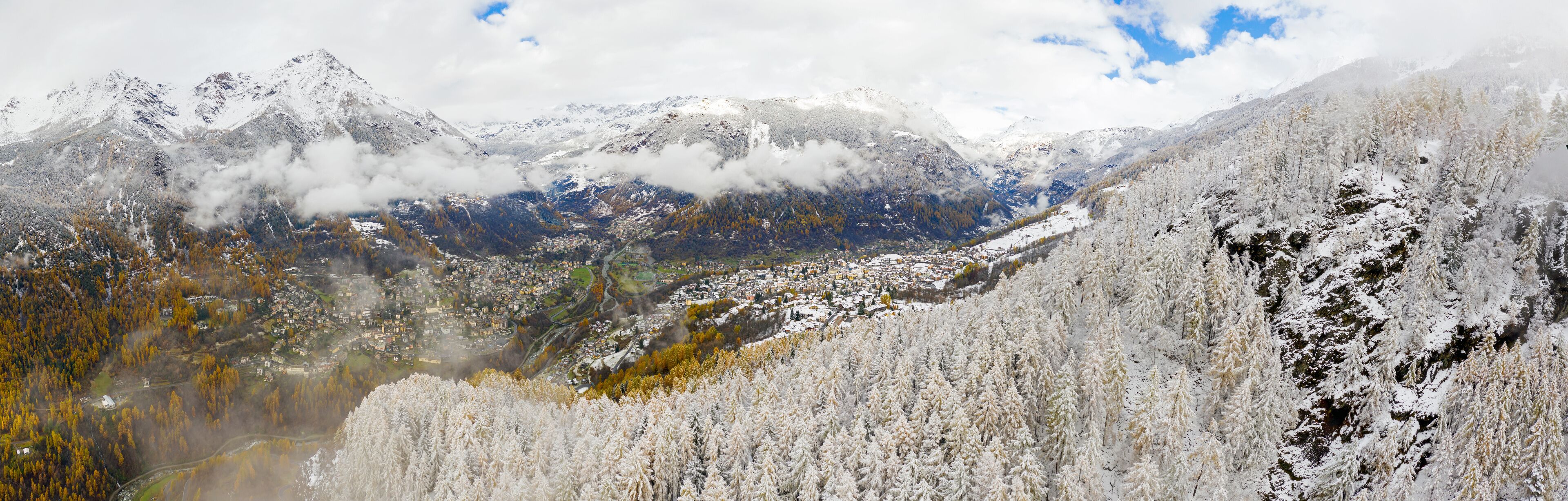 A snow-covered mountain range with a valley town below.