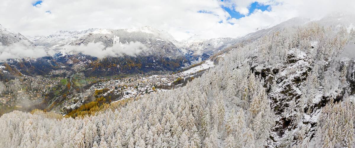 A snow-covered mountain range with a valley town below.