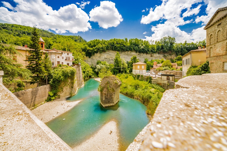 the serenity of a quiet village in the hills of Romagna countryside in Italy, while the cool waters of a placid river bathe the hamlet; Shutterstock ID 436128472; Purchase Order: -