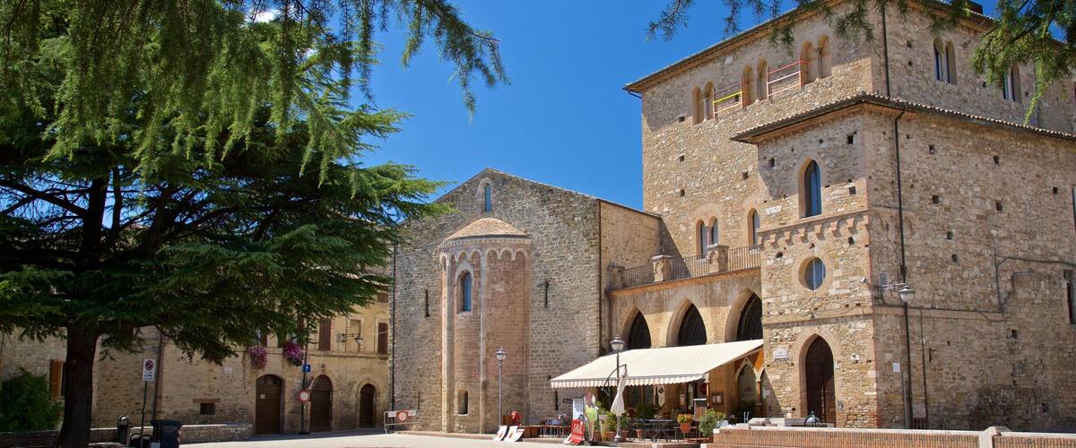 A historic stone building with arched windows and a central tower.