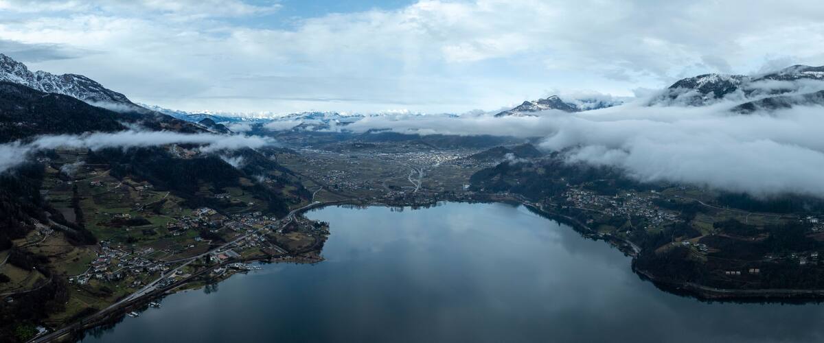 A lake surrounded by mountains and clouds.