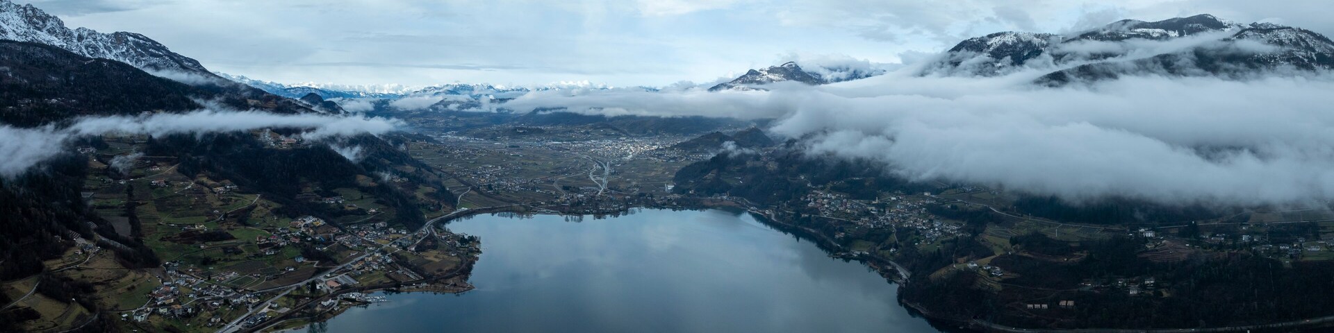 A lake surrounded by mountains and clouds.