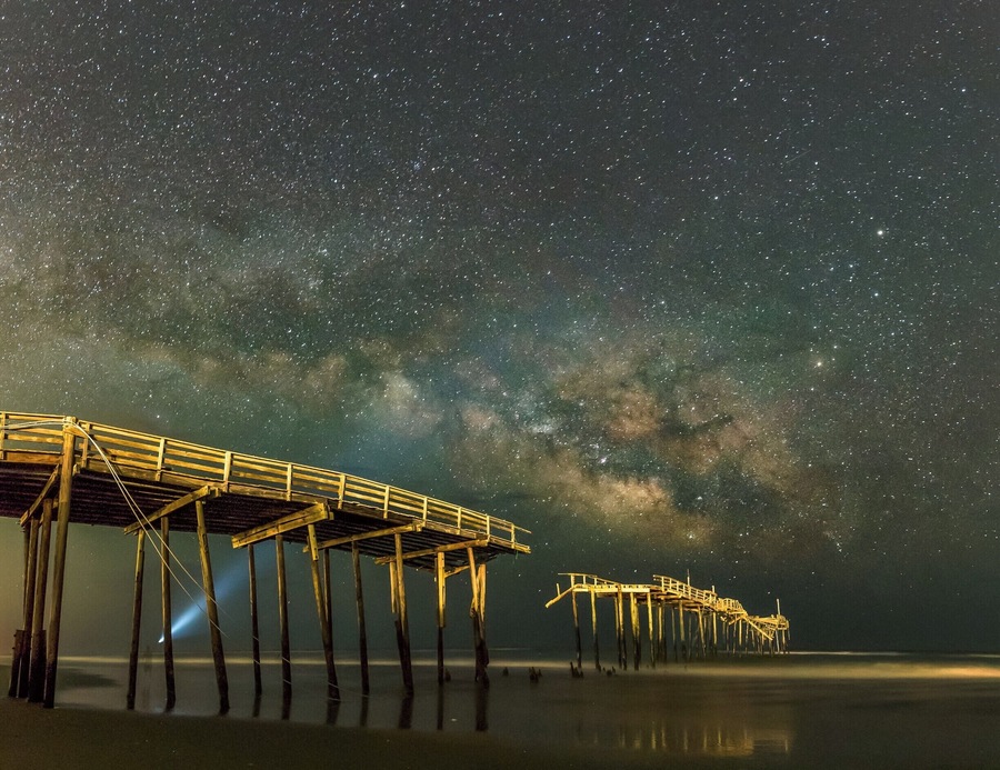 "The ghosts of yesteryears wander amidst the ruins seeking eternal salvation..."
That is the very thought that passed through my mind the moment I laid my eyes on this image on my computer screen. The ghostly silhoutte of the torch bearer and the mist at the base of the pier and the ruined pier add the necessary atmosphere to make this image dramatic to my eyes.
This image has been taken at the Cape Hatteras Fishing Pier, also called the Frisco Pier. It was damaged by Hurricane Earl a few years ago and now mostly serves as a tourist attraction. It might be torn down eventually (I hope not) but for now, it's worth a visit.
This is close to the Cape Hatteras Lighthouse, which is another location worth a visit.
#Astrophotography #NC #Pier #USA #beach #galaxy #milkyway #night #starscape #nightscape #ocean #ruins #sea #space #stars #water #bestof5 #abandoned