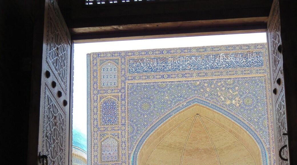 The view from inside the Kalyon Mosque outwards into the opposite portal is stunning as it catches the morning's sun rays. Here you see a gaggle of Uzbeks and fellow travellers at the entrance. #colorful