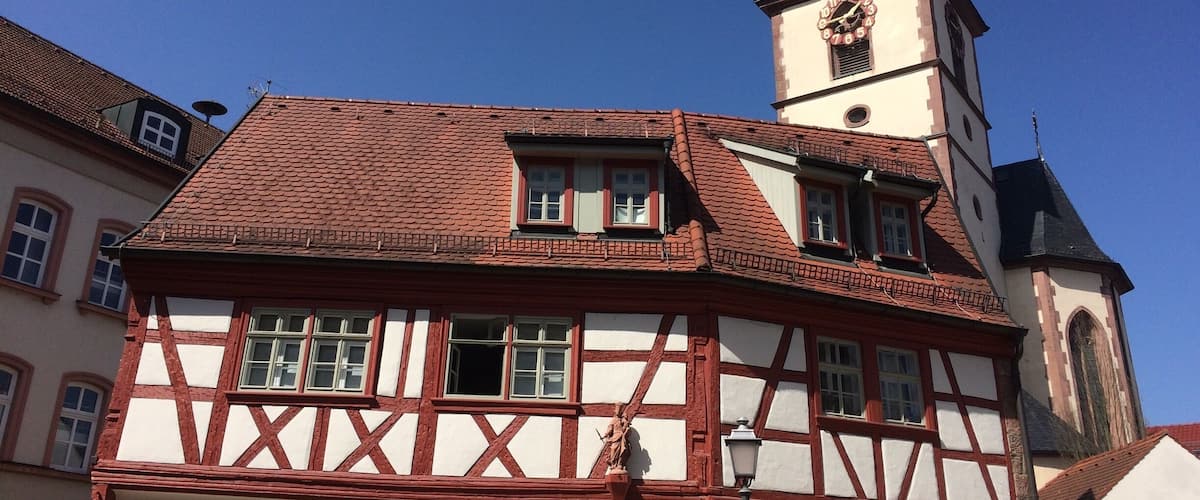 A half-timbered building with a clock tower and a statue on the roof.
