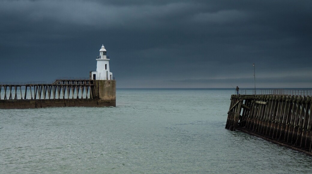 Lone man fishing on a very stormy day in Blyth, Northumberland.