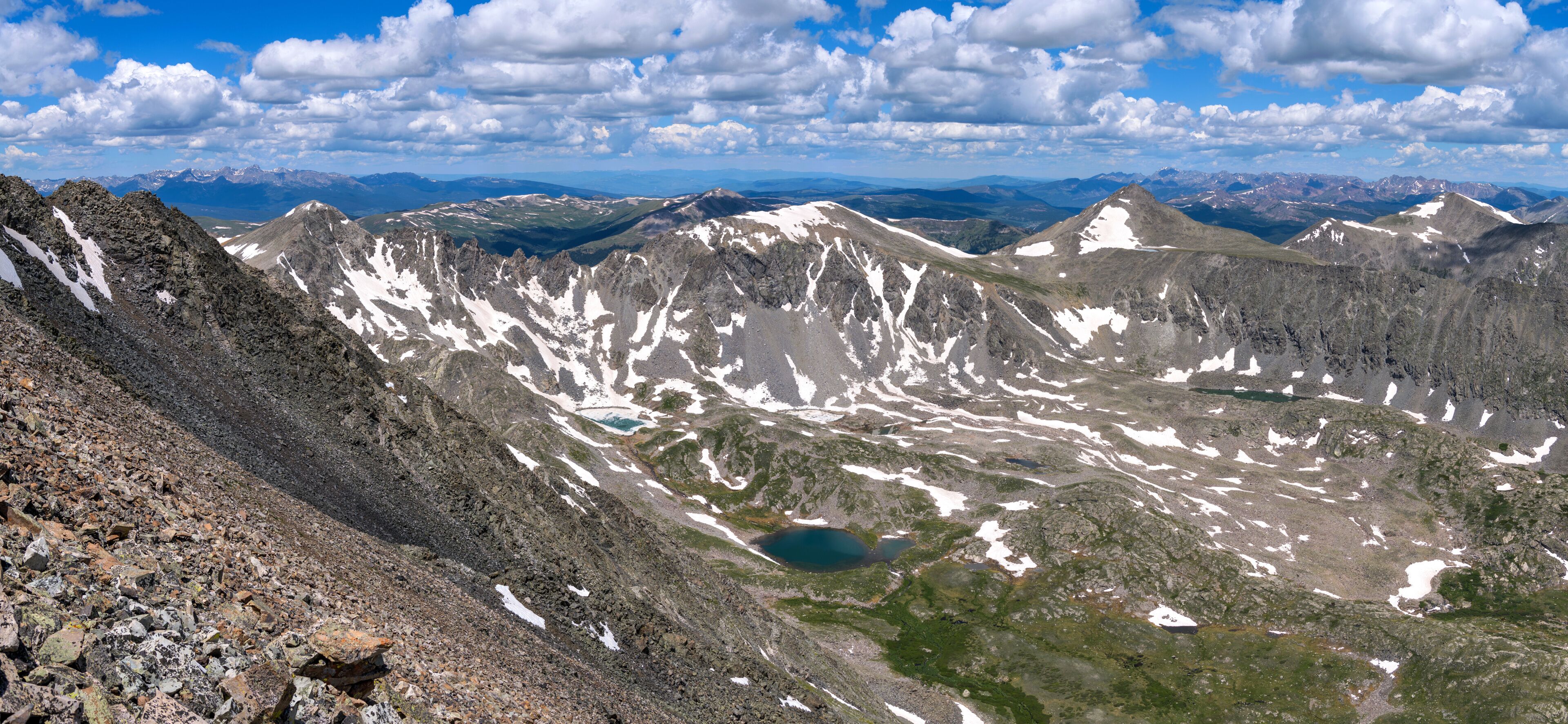 Summer Mountain Top - White clouds rolling over rugged mountain peaks and blue alpine lakes, as seen from summit of Quandary Peak looking towards northwest, on a sunny Summer day. Colorado, USA.