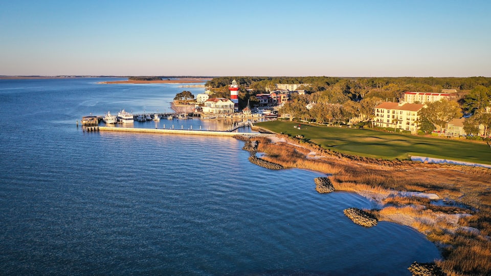 A coastal town with a lighthouse, marina, and golf course.