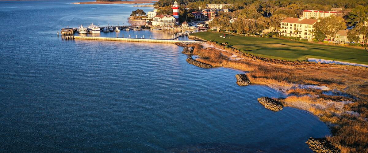 A coastal town with a lighthouse, marina, and golf course.