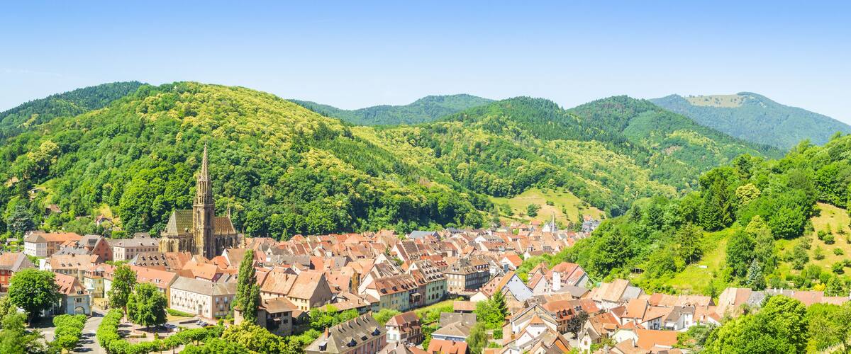 A town nestled in a valley surrounded by lush green hills.