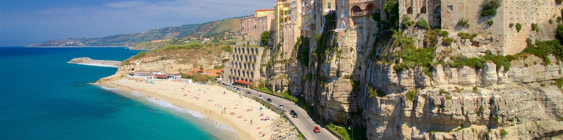 Un pueblo costero con playa, una carretera y edificios históricos.