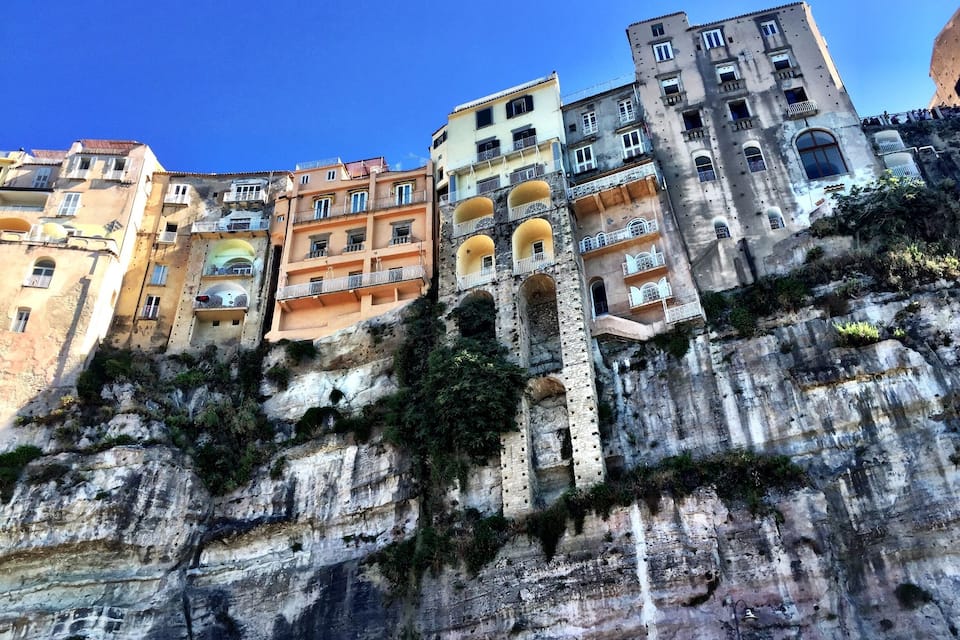 A coastal town with colorful buildings perched on a rocky cliff.