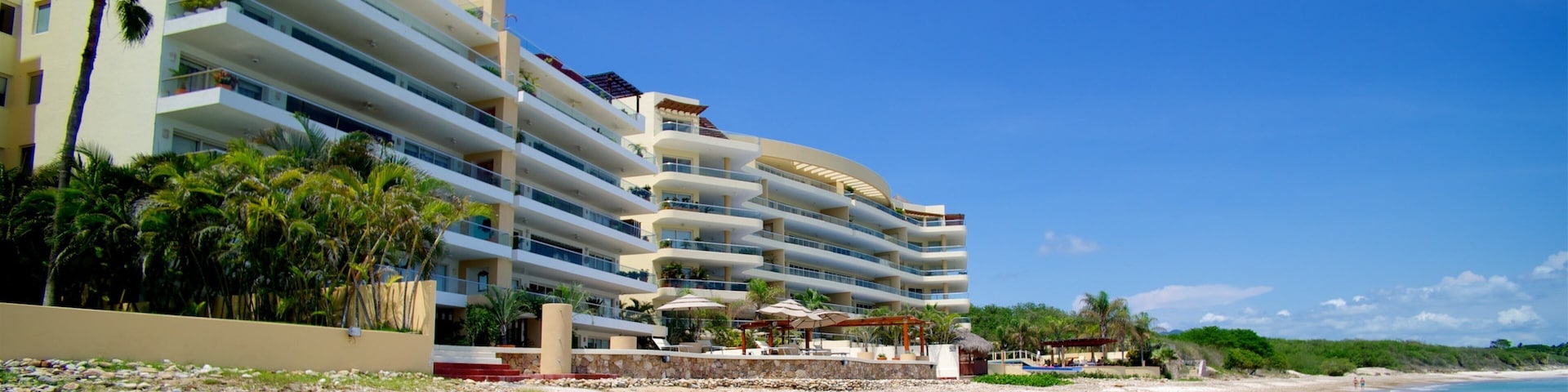 Mexico showing a sandy beach, a coastal town and a bay or harbor