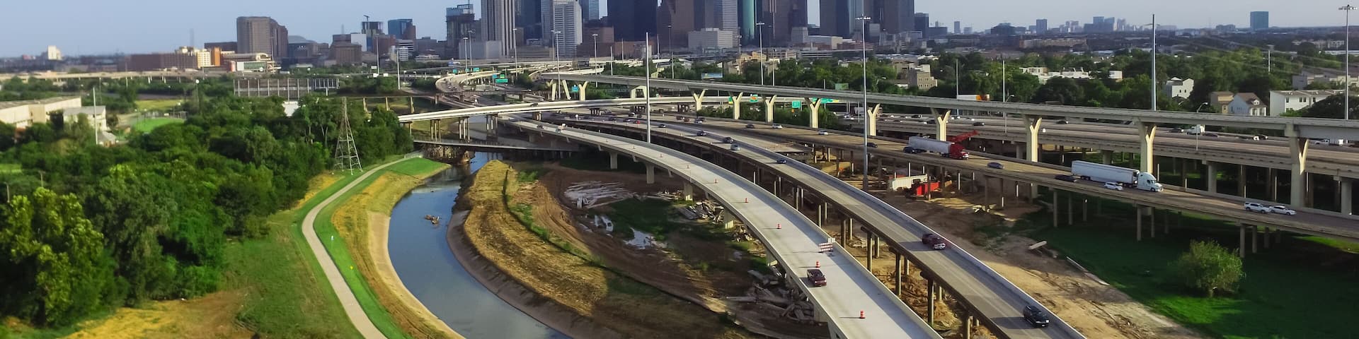 Aerial view downtown and interstate I45 highway with massive intersection, stack interchange, road junction overpass and elevated road construction at sunset from northwest side of Houston, Texas, USA