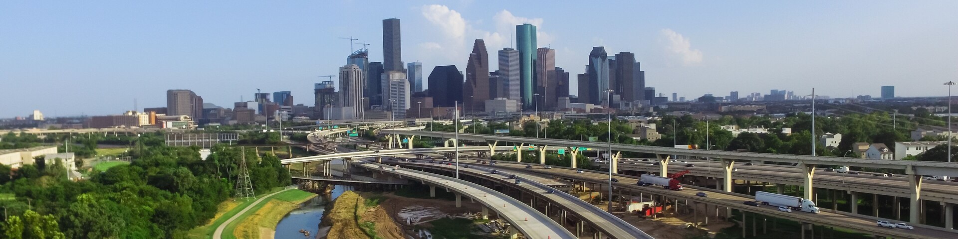 Aerial view downtown and interstate I45 highway with massive intersection, stack interchange, road junction overpass and elevated road construction at sunset from northwest side of Houston, Texas, USA