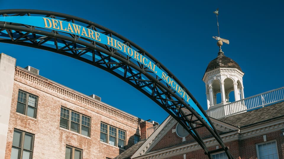 A blue archway with the text "Delaware Historical Society" against a clear blue sky.