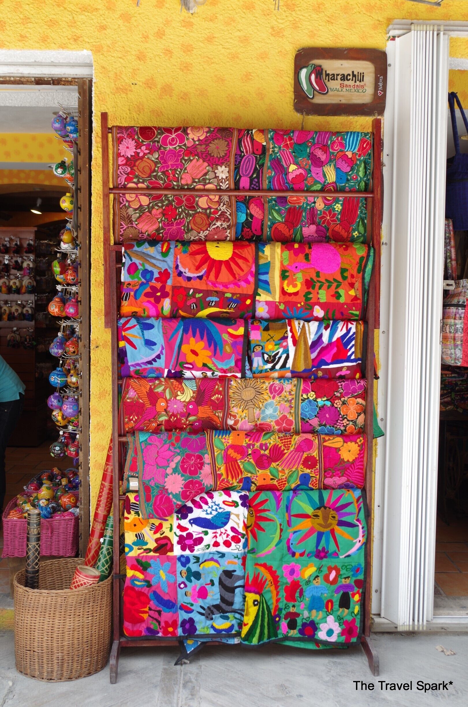 Un colorido exhibición de cestas tejidas y textiles en un puesto de mercado.