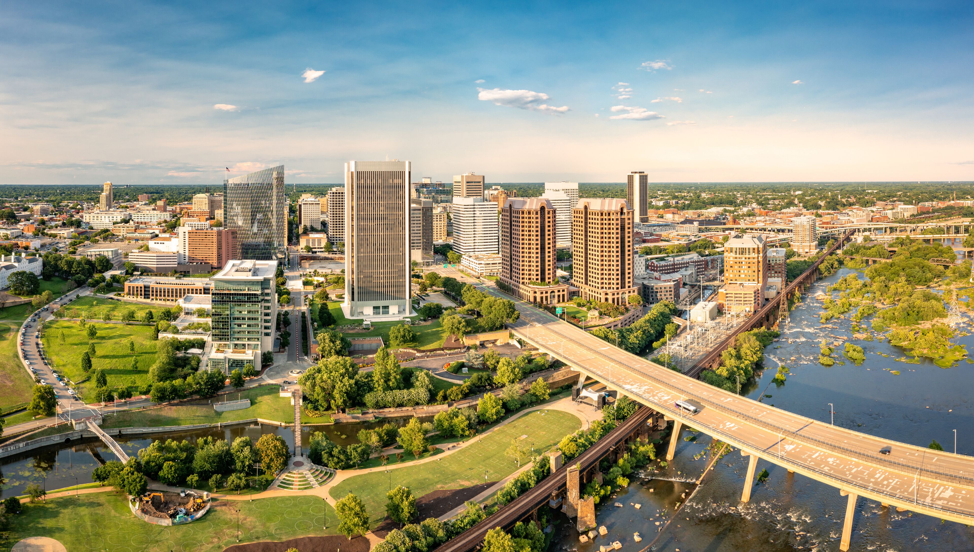 A cityscape with modern high-rise buildings, a river, and a bridge.