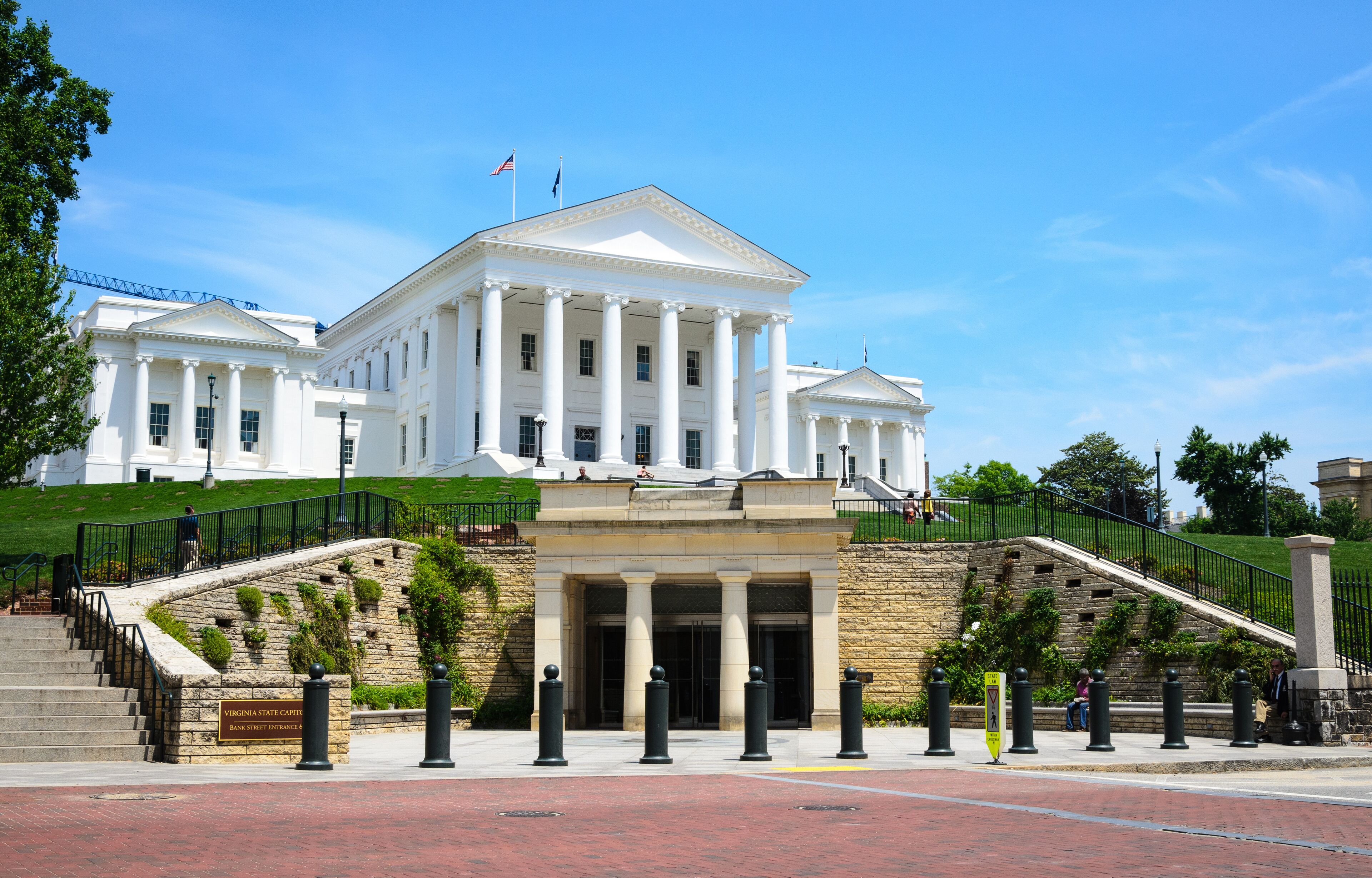 A large white building with columns and a flag on top.