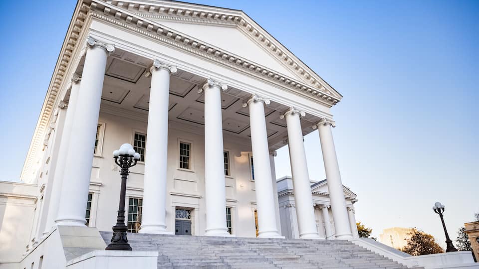 A neoclassical building with large columns and a grand staircase leading to the entrance.