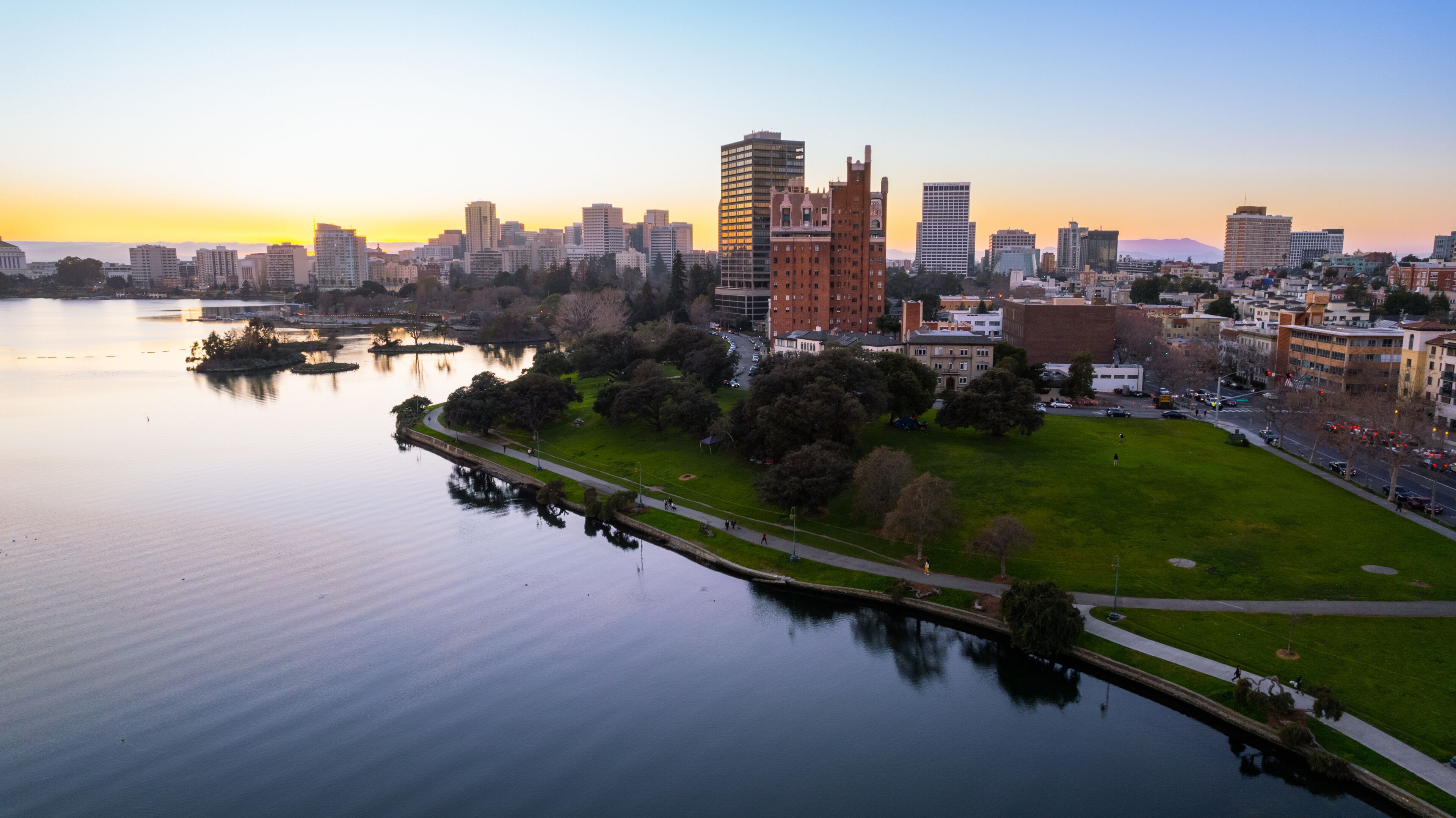 Eine Stadtansicht mit einem Fluss, einem Park und einer Mischung aus modernen und historischen Gebäuden.