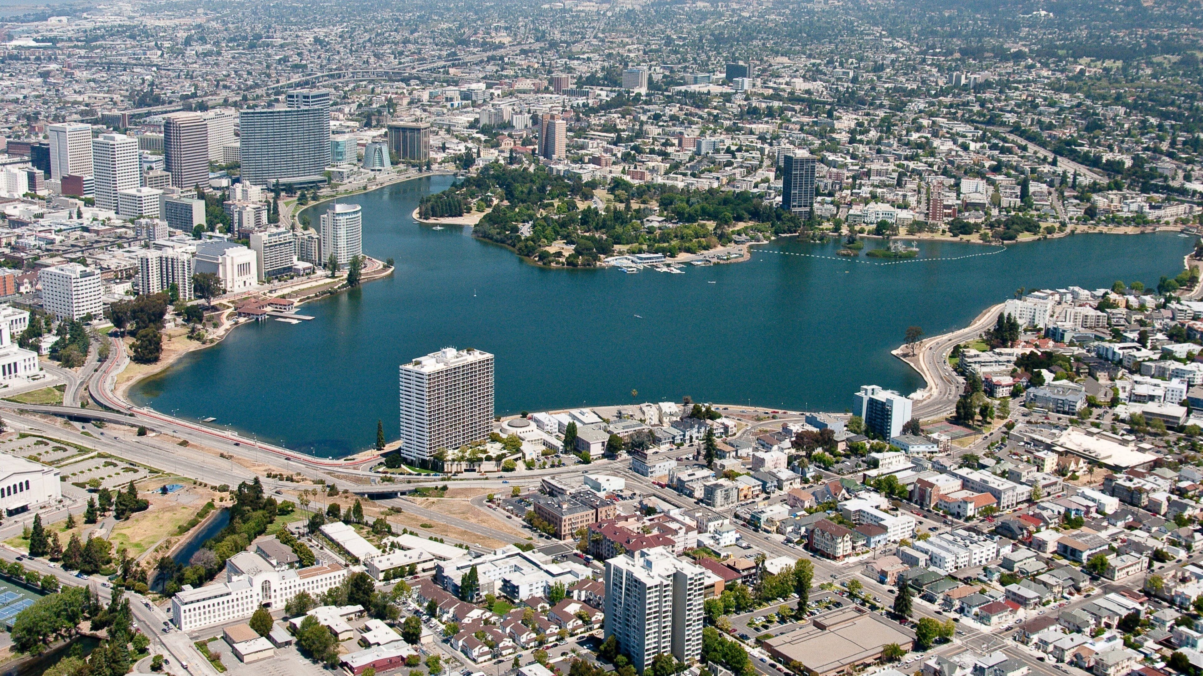A cityscape with a large body of water, high-rise buildings, and a mix of residential and commercial areas.