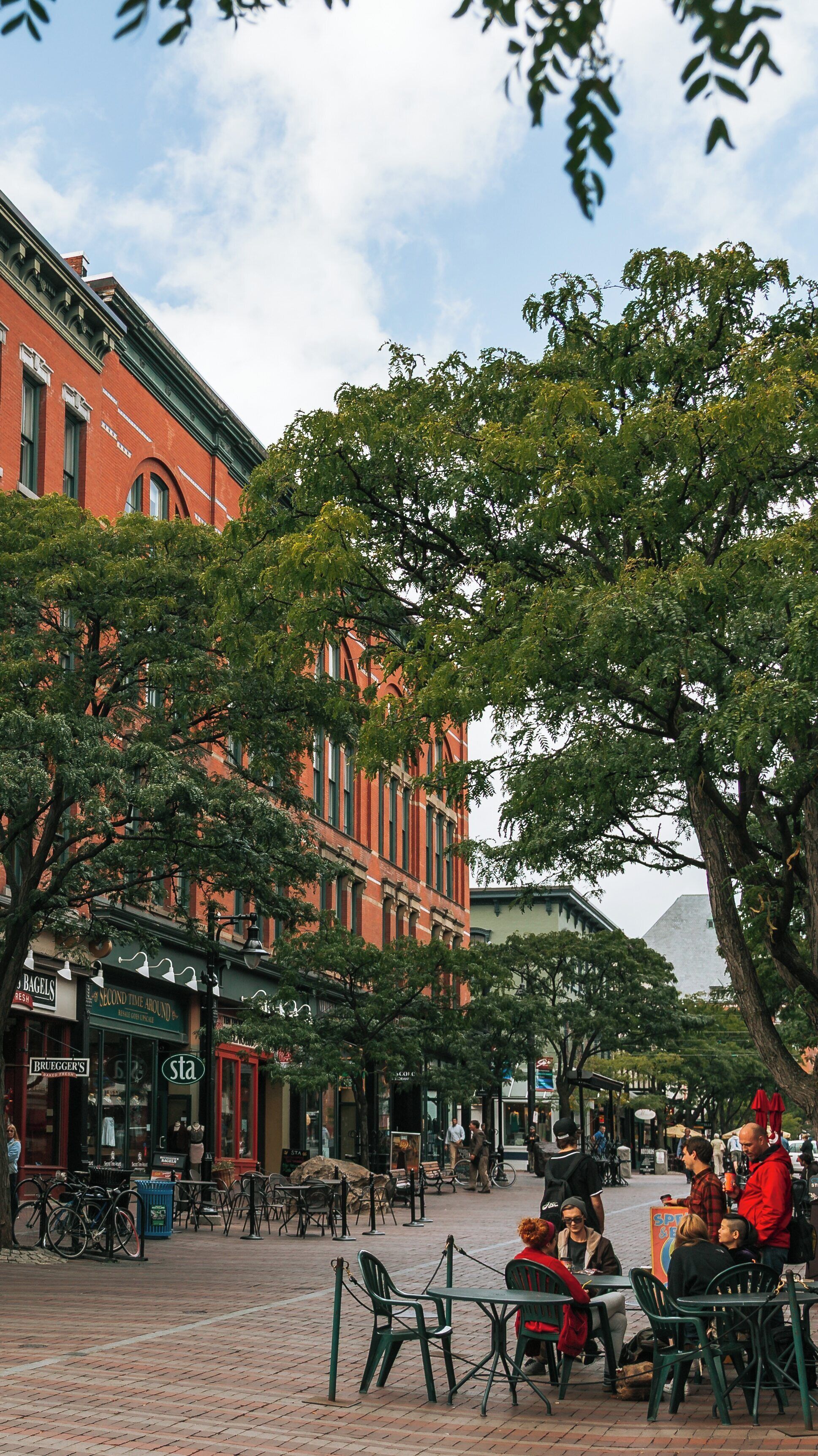 Charming Church Street Marketplace bustling with people enjoying outdoor dining and shopping in downtown Burlington, Vermont on a clear day
