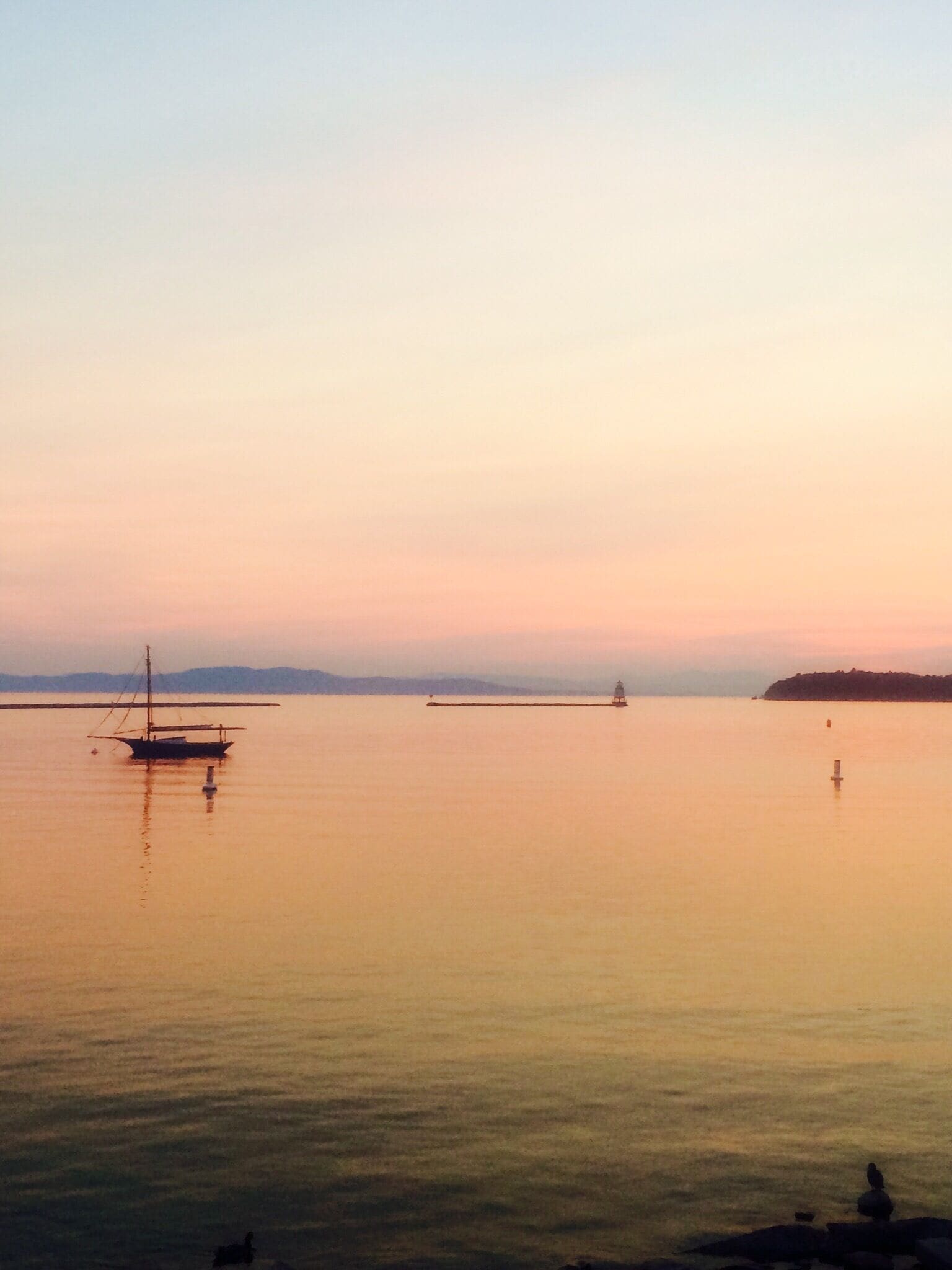 Waterfront Park in Burlington, VT USA at sunset. Looking across Lake Champlain to New York State. We live steps from here on Church Street and can provide travelers with lots of Burlington tips! #burlington #vermont #lakechamplain #harbor #welovetoexplore