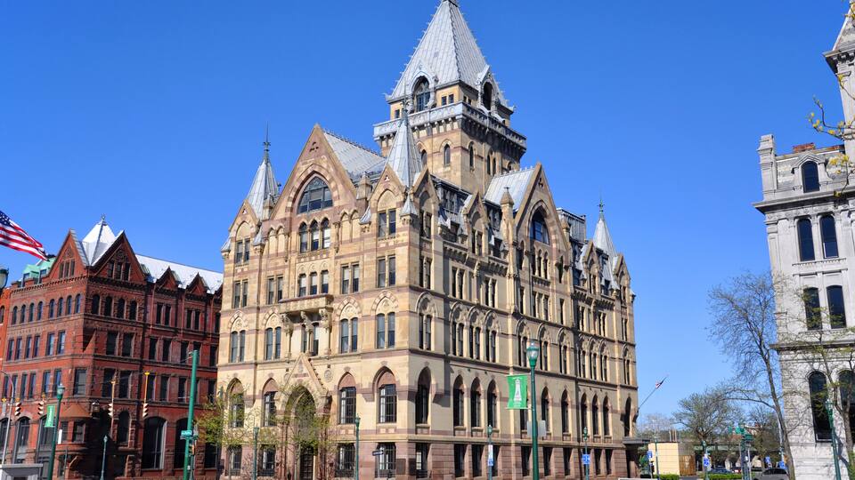 A historic building with a pointed roof and arched windows.