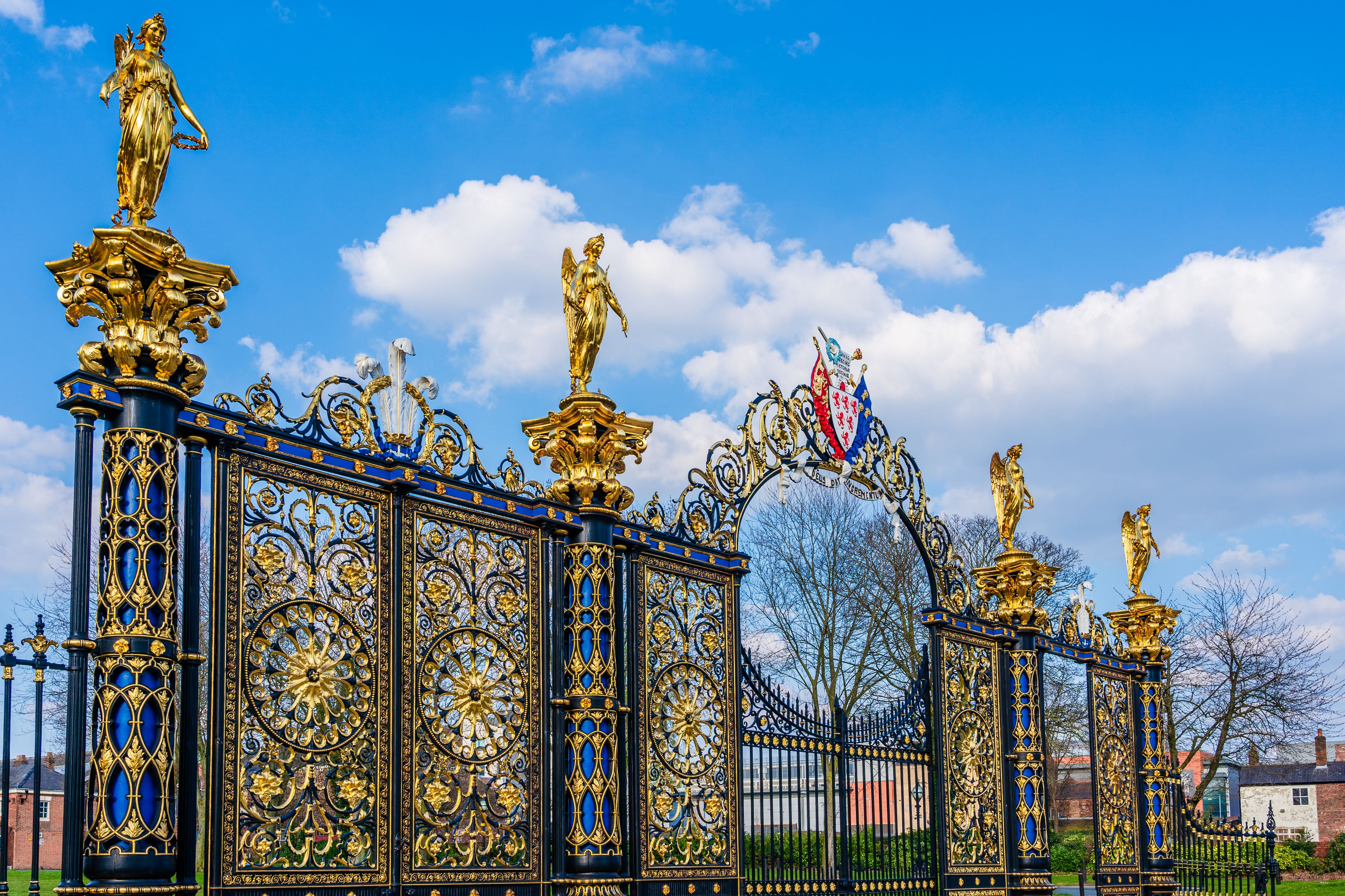 A golden ornate gate with statues and intricate designs.
