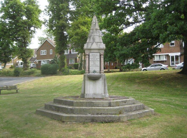 Pinner: The Tooke drinking fountain. The fountain was erected in 1886 by the inhabitants of Pinner in grateful memory of William Arthur Tooke, JP, a local dignitary. It is on a small triangular green at the junction of Church Lane and Moss Lane. With its columns of red granite and with its grey granite broach spire it is a Grade II Listed structure. Unfortunately its drinking fountain capabilites appear to have been lost for some time.