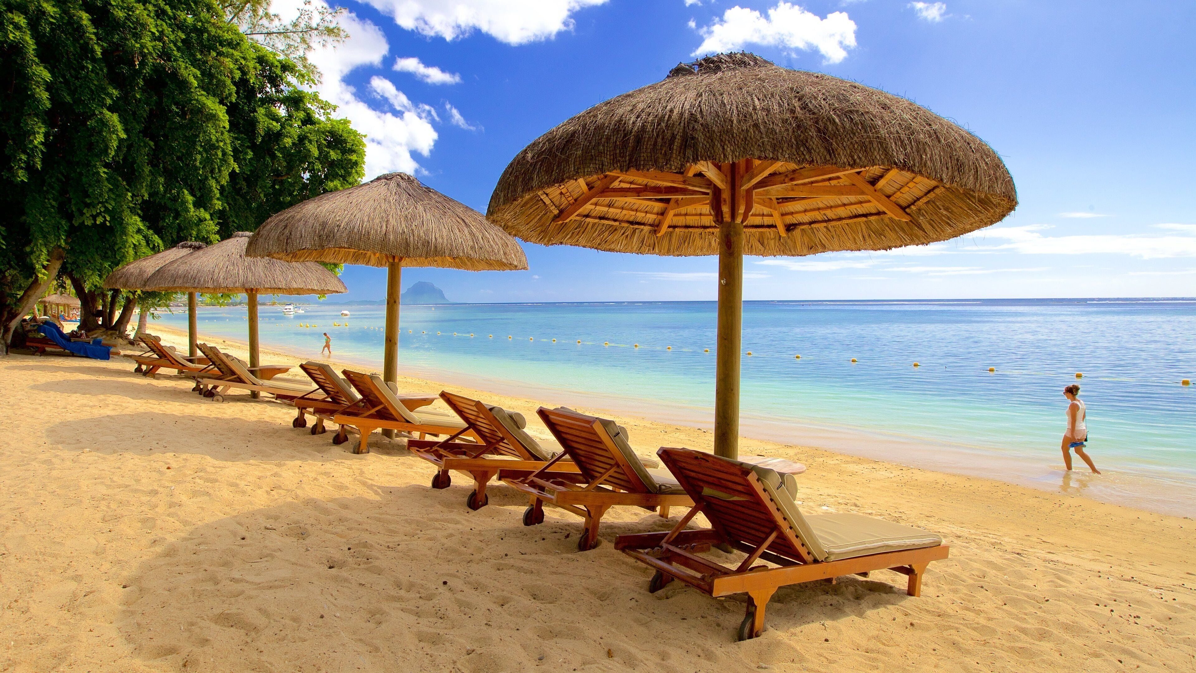 Flic-en-Flac featuring a sandy beach and a luxury hotel or resort as well as an individual femail