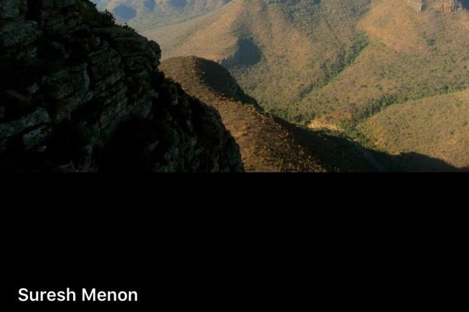 Paisagem montanhosa com terreno acidentado e vales profundos.