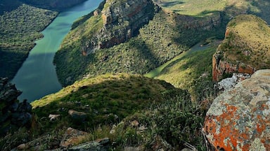 Paisagem montanhosa com um rio serpenteando por ela.