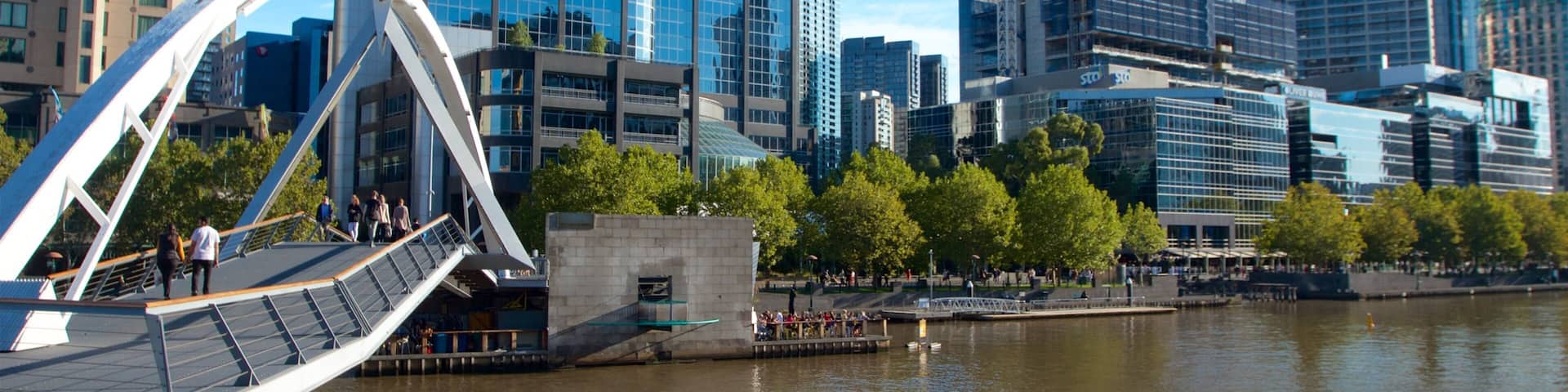 A modern cityscape with a river, a bridge, and several high-rise buildings.