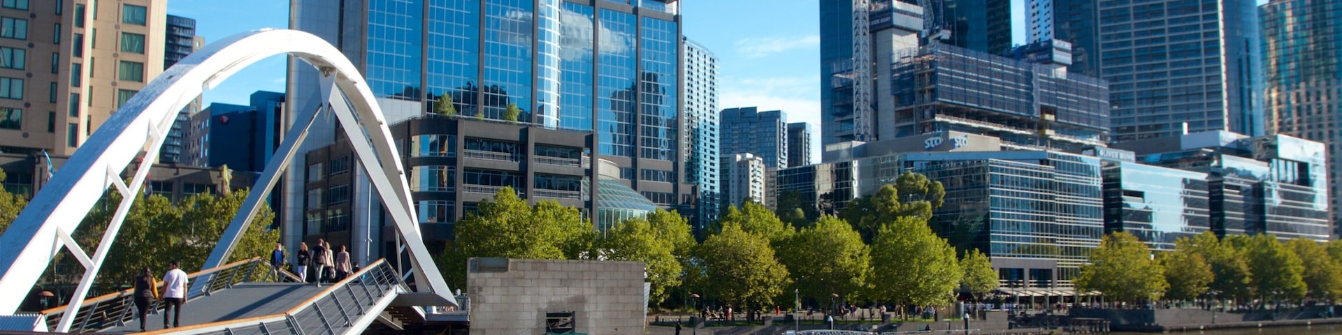 A modern cityscape with a river, a bridge, and several high-rise buildings.