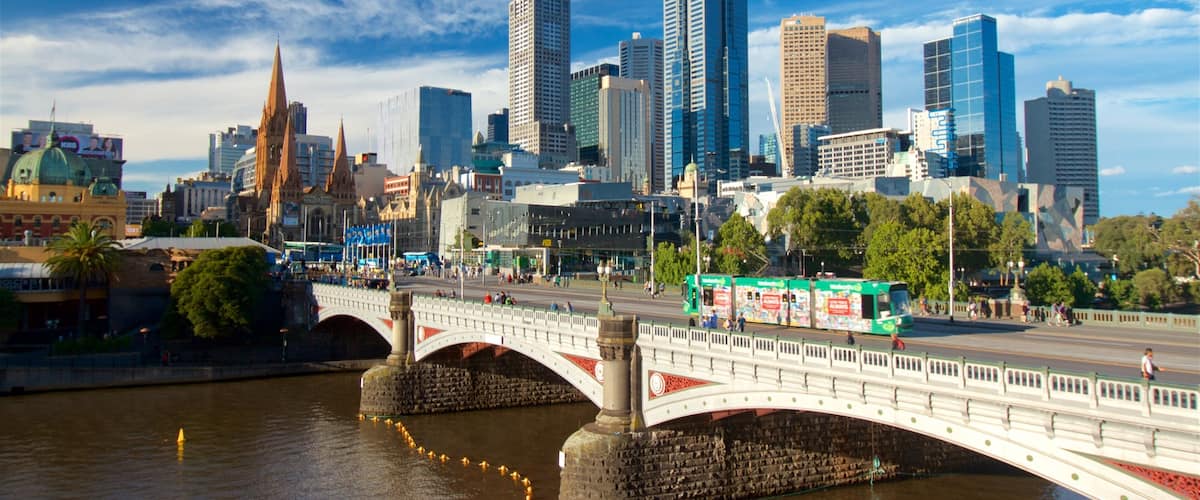 A cityscape with a prominent bridge over a river, modern skyscrapers, and historic buildings.