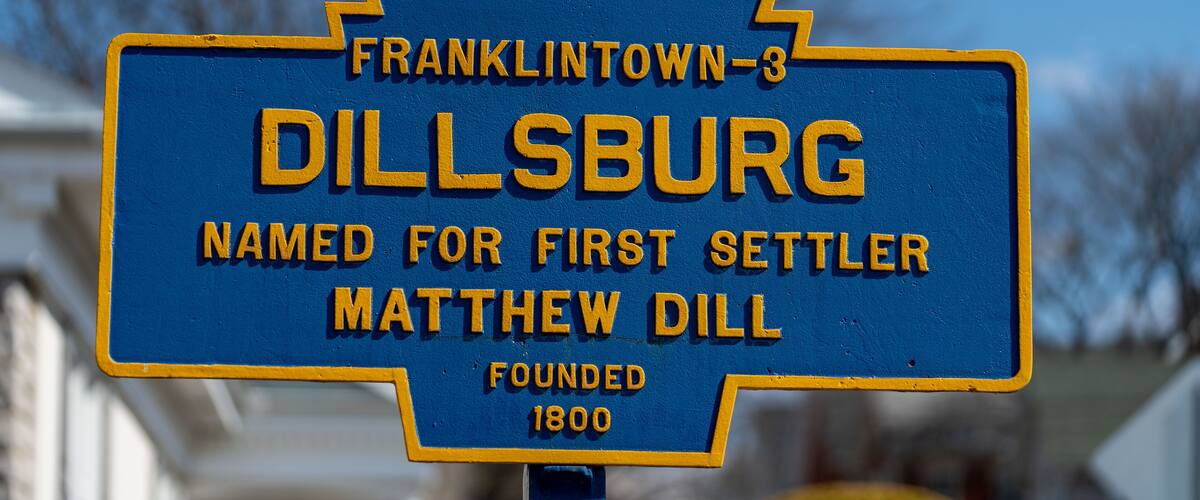 A blue and yellow historical marker sign for Dillsburg, named for first settler Matthew Dill, founded in 1800.