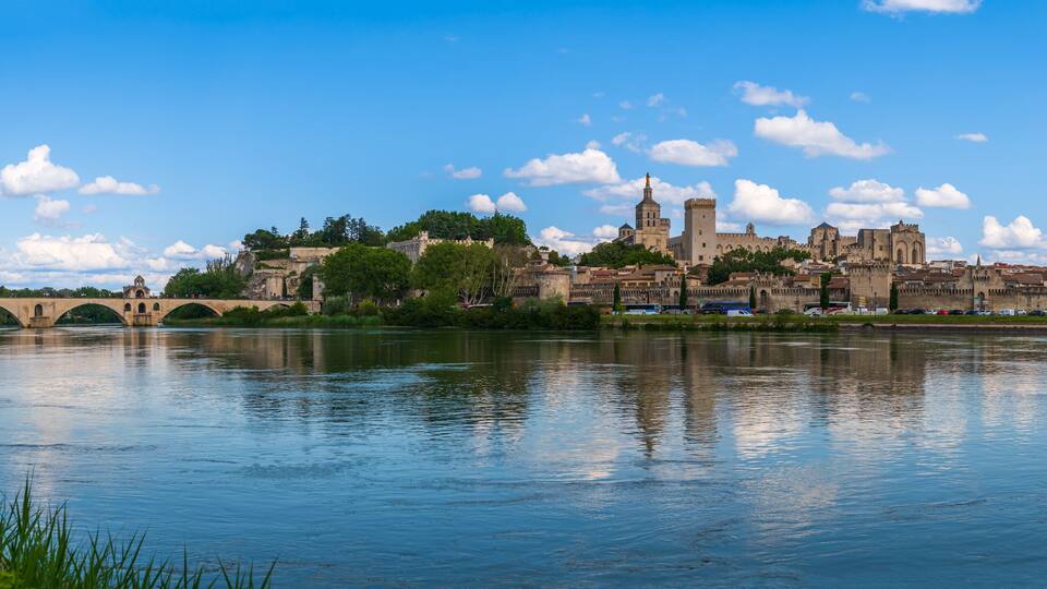 A historic city with a river, a bridge, and a prominent castle-like structure.