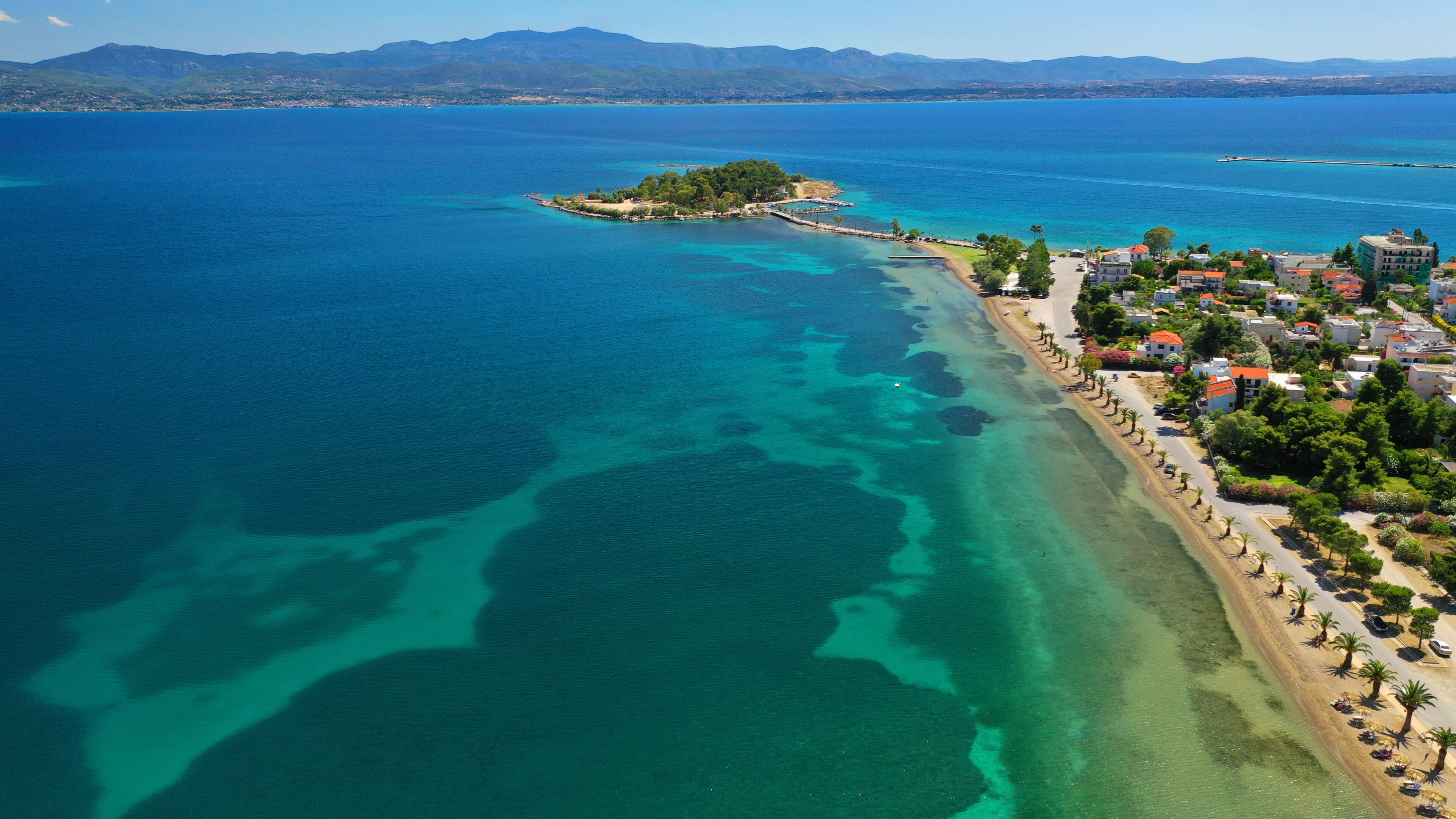 Aerial drone photo of famous island of dreams or Pesonisi connecting with small road with seaside fishing village of Eretria, Central Evia island, Greece