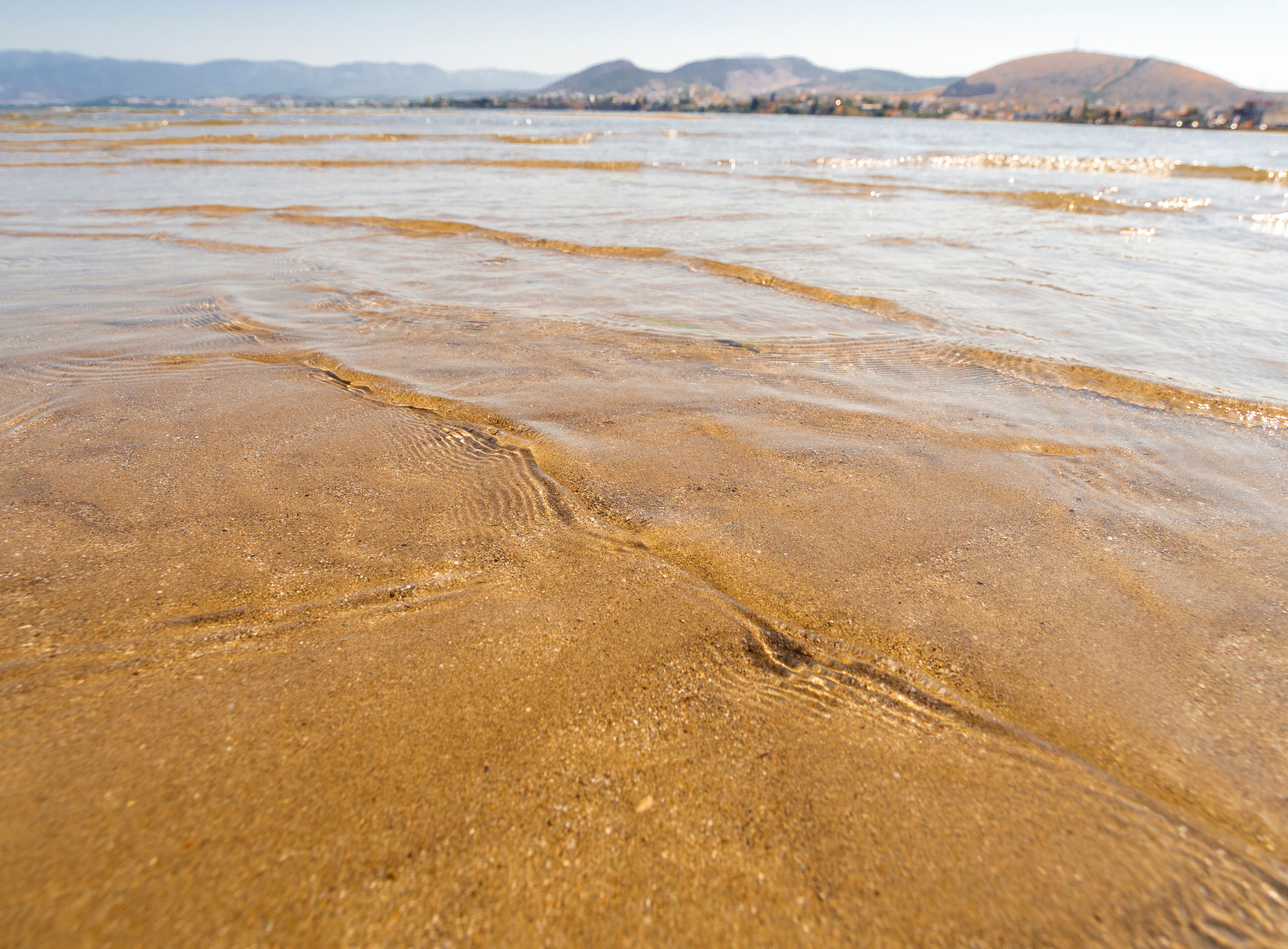 Panoramic views of the sandy beach,  mountains  the island of Evia on Liani Ammos beach in Halkida, Greece on a Sunny summer day