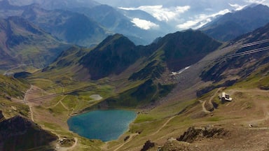 A mountainous landscape with a lake, a bridge, and distant mountains.