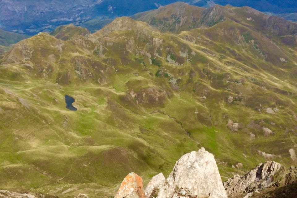 Un paisaje montañoso con afloramientos rocosos y un valle.