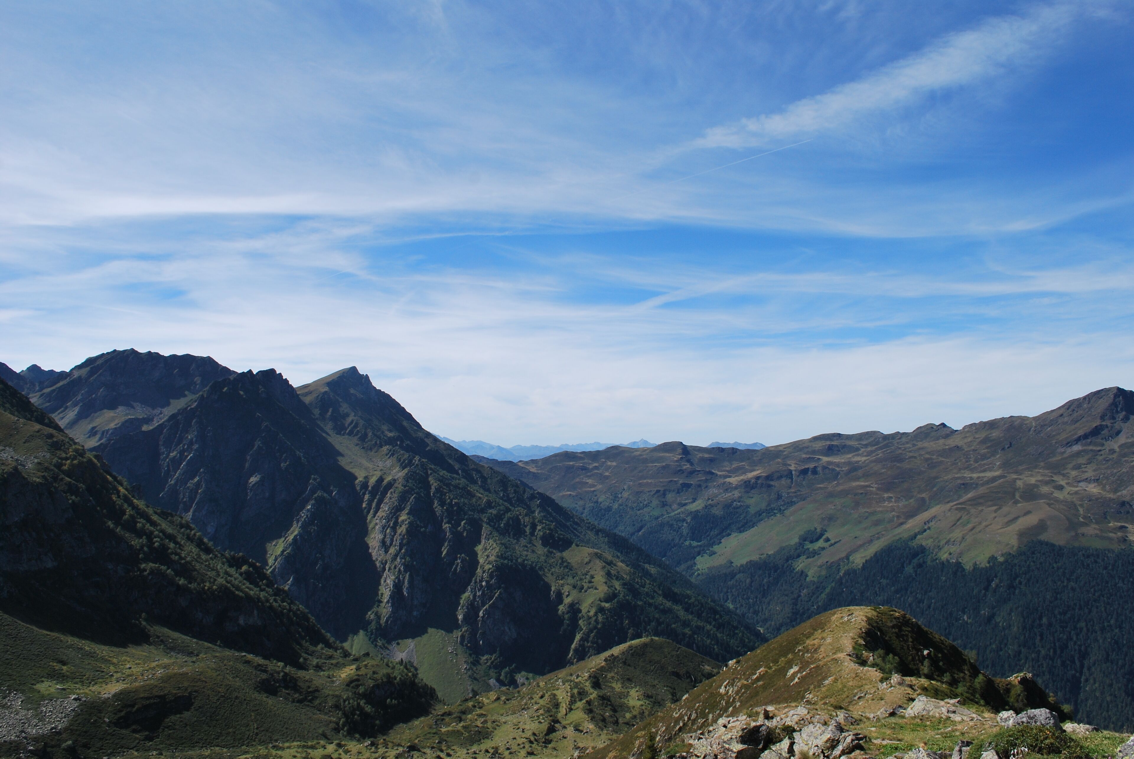 A mountainous landscape with rugged peaks and valleys under a clear sky.