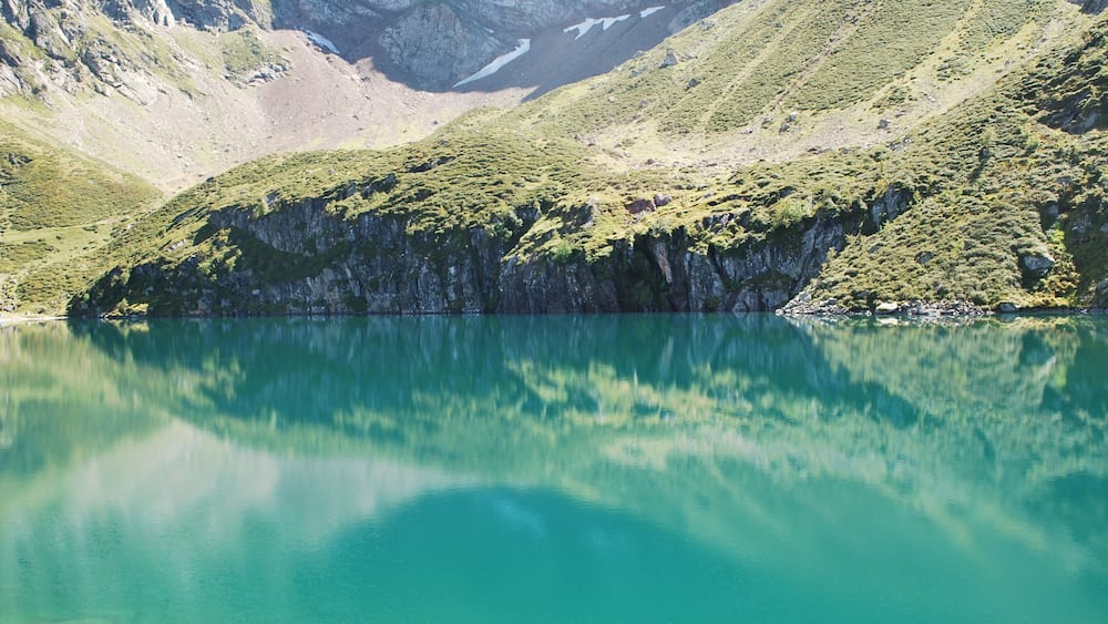 Un lac de montagne entouré d’un paysage accidenté et d’une végétation clairsemée.