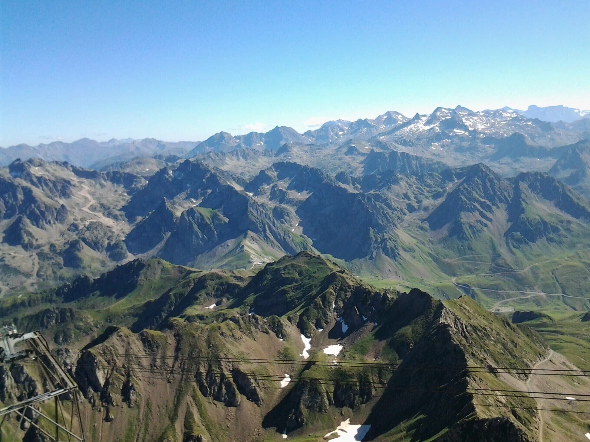 A mountainous landscape with rugged peaks and patches of snow.